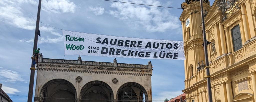 Saubere Autos sind eine dreckige Lüge – Bannerprotest von ROBIN WOOD-Aktivist*innen gegen die anstehende Auto-Show IAA in München, 01.09.2023 (Foto: ROBIN WOOD)